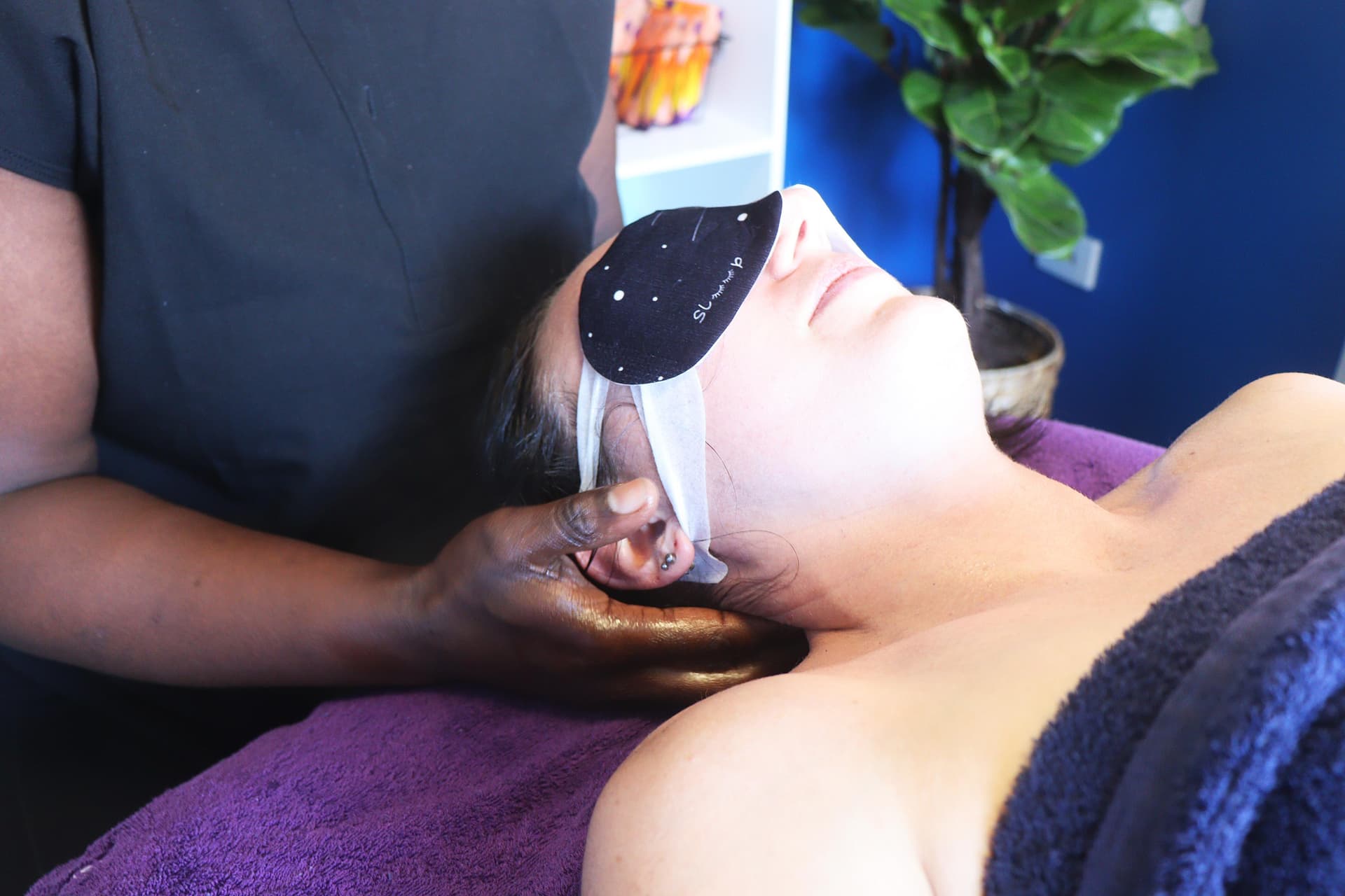 Therapist performing gentle facial and neck massage as part of TMJ treatment